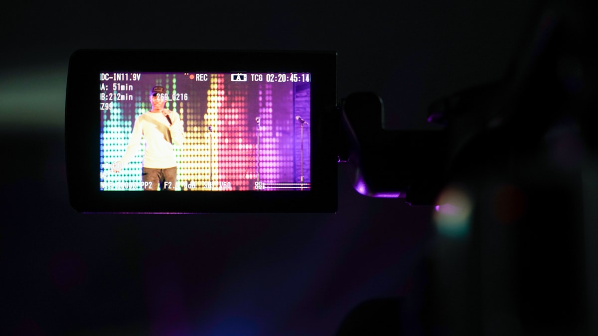 A content creator recording a YouTube video to a camera with a teleprompter script on screen
